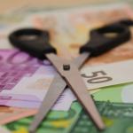 Paire de ciseaux posée sur des billets de banque (€)
