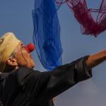 Femme clown en train de jongler avec des foulards bleus, blancs et rouges
