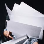 Homme assis lançant un tas de feuilles de papier