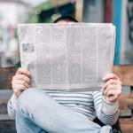 Homme tenant un journal entre ses mains